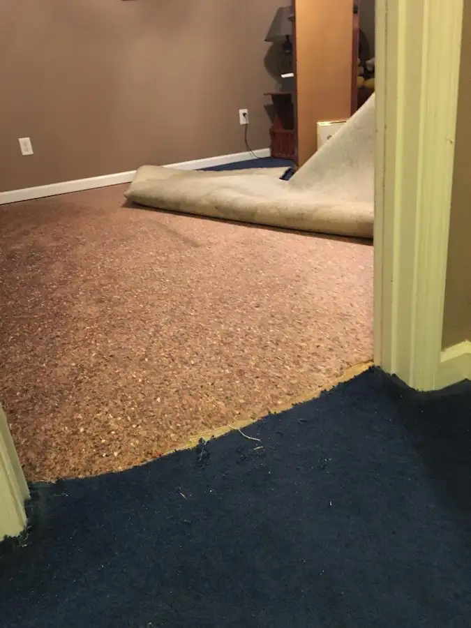 Carpet pad removal revealing water damage during Water Mitigation Services in Atlanta